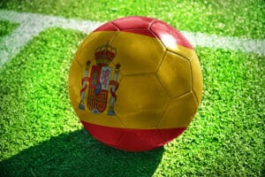 pelota de fútbol pintada con los colores de la bandera española sobre el césped de un campo de fútbol bandera española pelota de fútbol